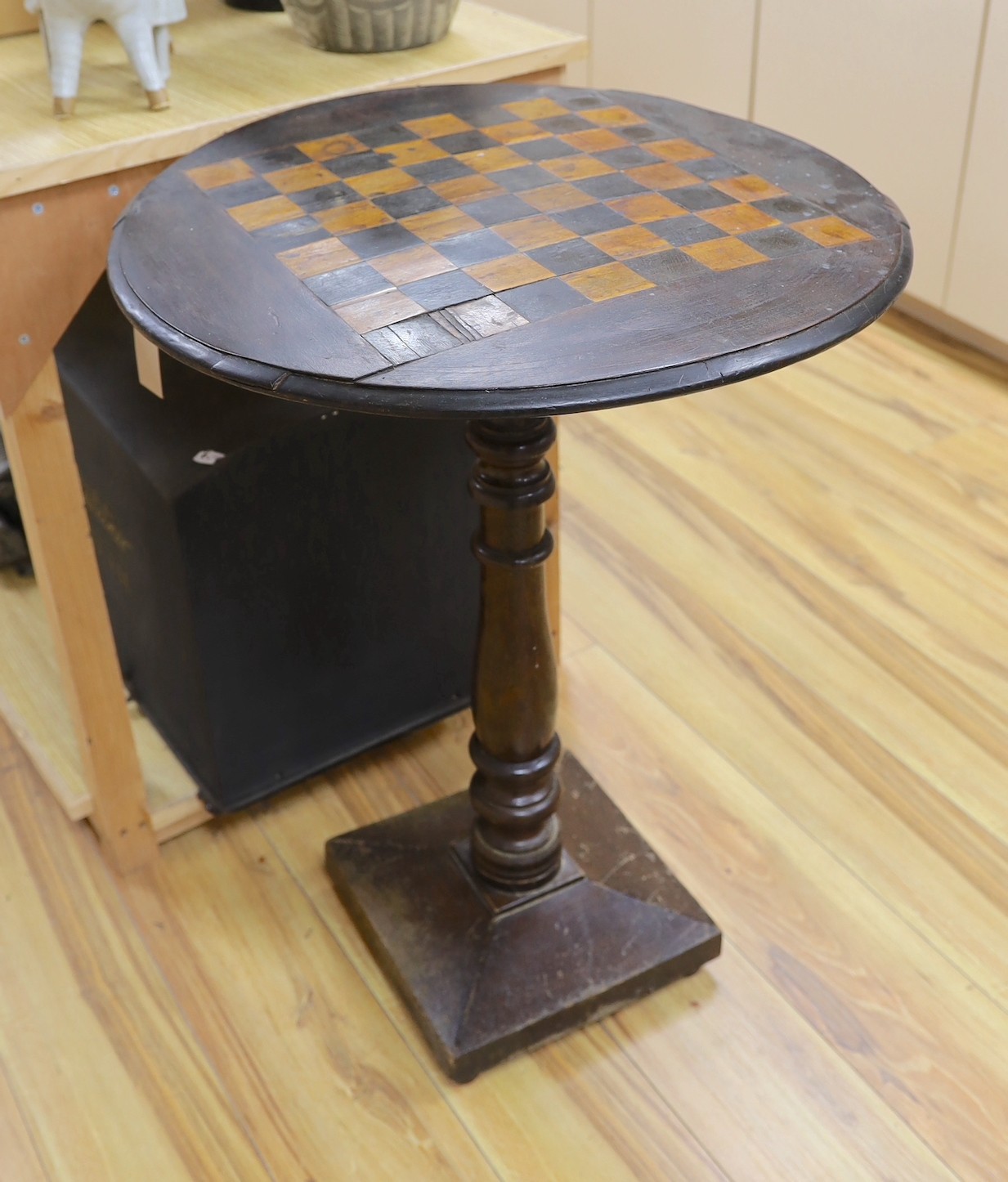 A stained pine inlaid chessboard top table, 75cm high, 56cm diameter and a set of Staunton chess pieces